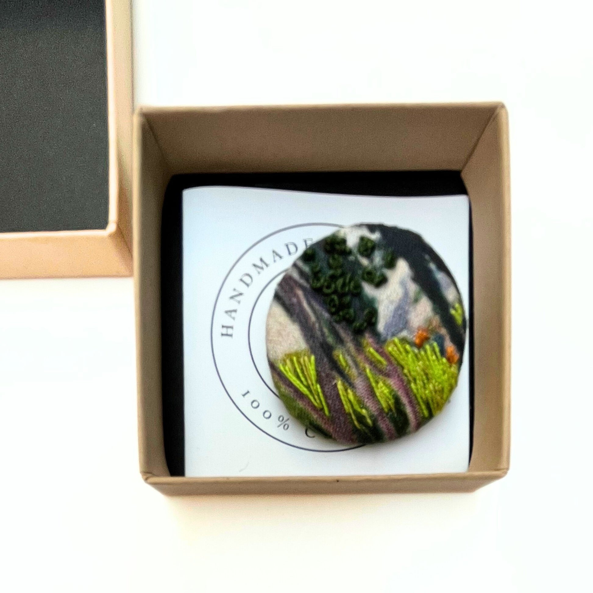 Anita Reynolds open brooch box containing brooch based on O'Conor's Farm at Lezaven