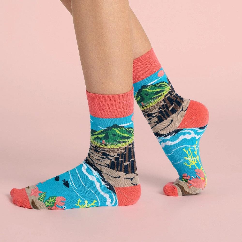 The socks on feet showing how the design wraps around the legs and feet.