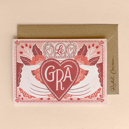 A6 sized greeting card with a floral and heart design, featuring the Irish word 'GRÁ' in the center, and a brown kraft envelope.