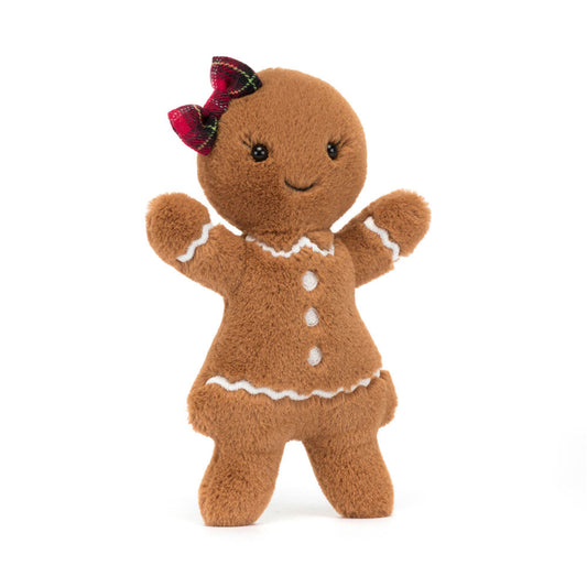 A cuddly toy of a gingerbread woman with white buttons and a red tartan bow on her head