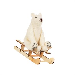 White Polar bear sitting on a wooden sleigh