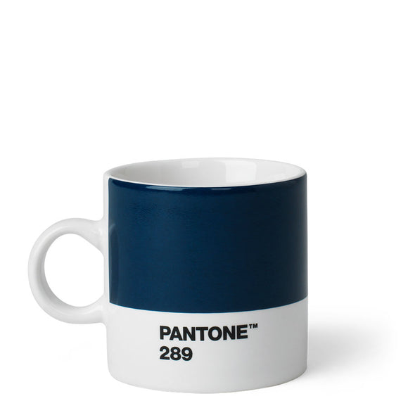 A short cup with a wide panel of navy blue around the top two thirds. Underneath is a white stripe with ‘Pantone 289’ in small black capitals. It has a small white handle and white inside.