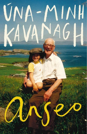 A photograph of a young girl wearing a flat cap sitting on an old man’s lap, both smiling. Green fields and the sea stretches out behind them. The author is across the top and title across the bottom, both in letters that look hand written.