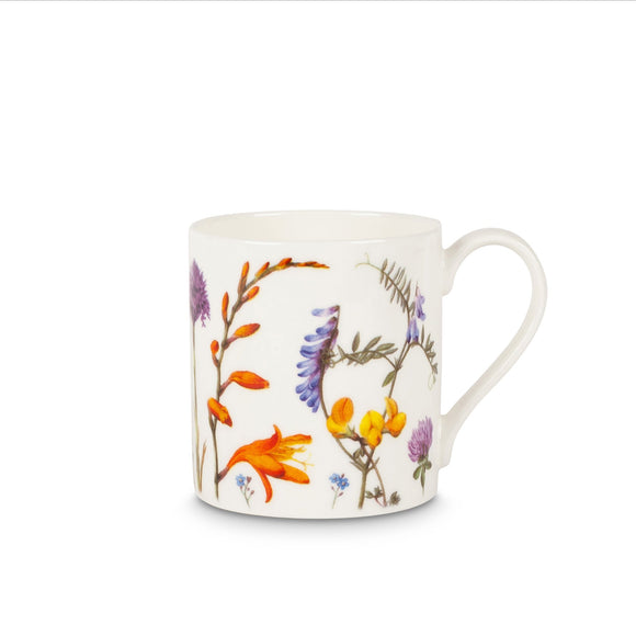 A white mug covered in paintings of flowers in different types and sizes, in purple, orange, pink and yellow.