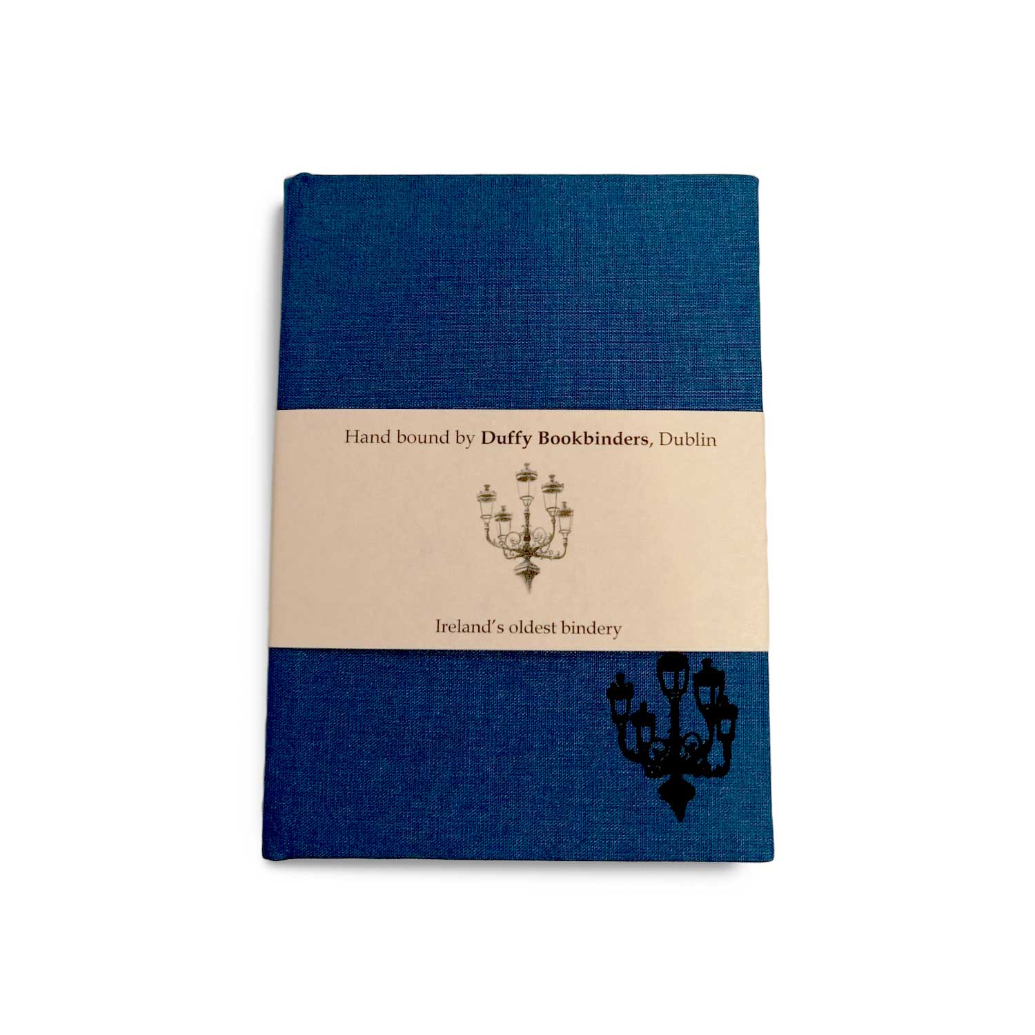 A blue clothbound notebook with a cream belly band around the centre. There is a simple line illustration of a street lamp with five lanterns in the bottom right corner of the notebook and on the band.