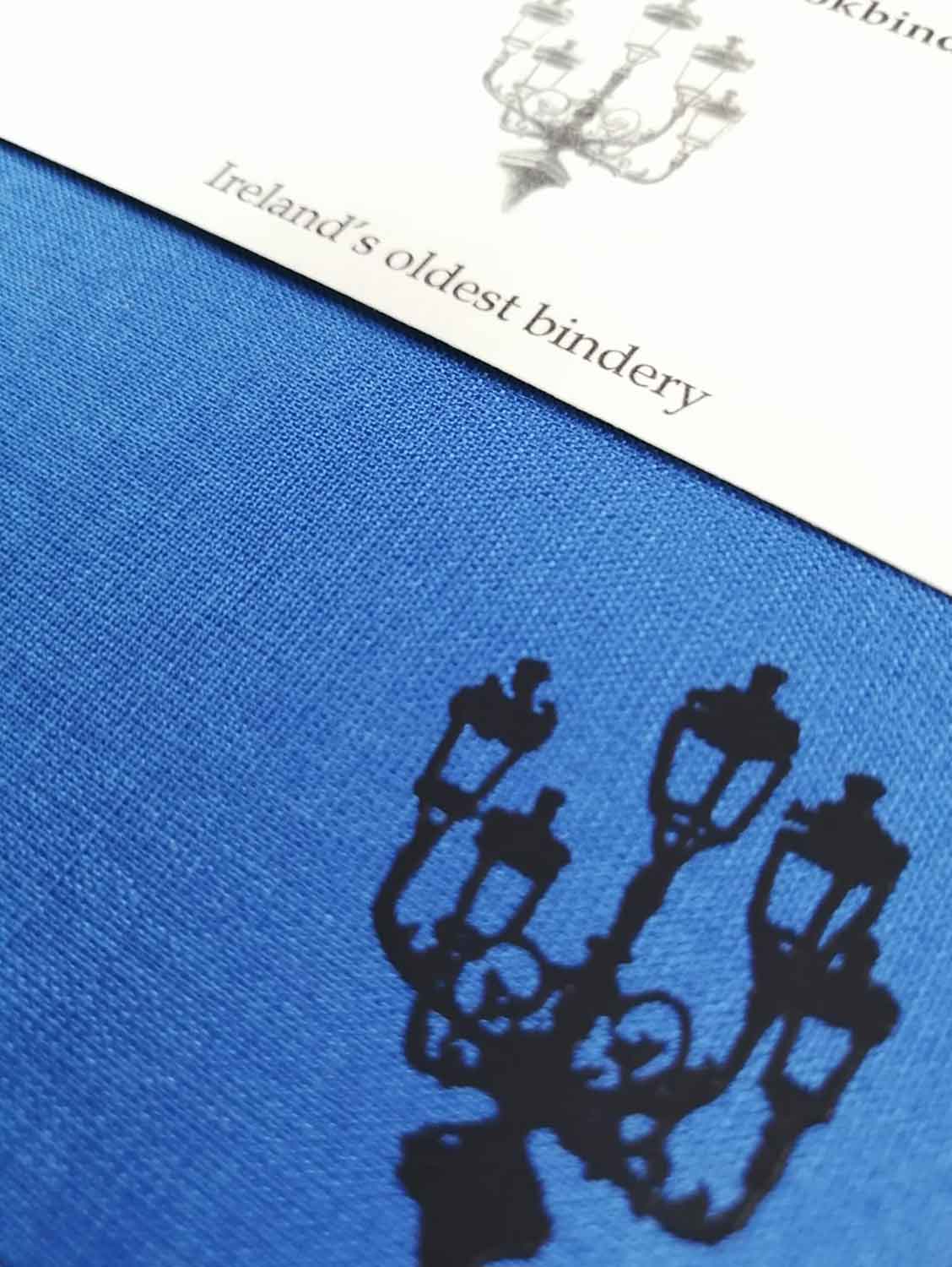 A close up of the lamp illustration also showing the texture of the blue cloth cover.
