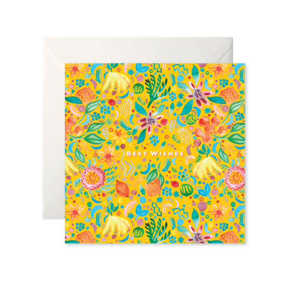 A yellow card with a colourful painted pattern of fruits and flowers. ‘Best Wishes’ is in the centre in white capital letters.