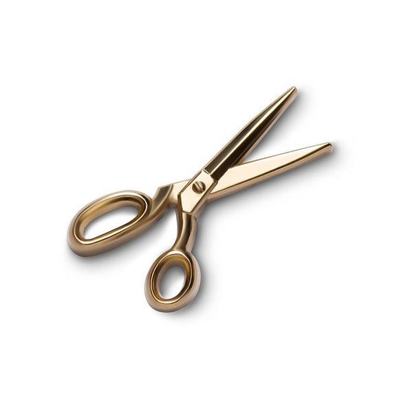 A metal gold coloured pin shaped like an open pair of scissors.