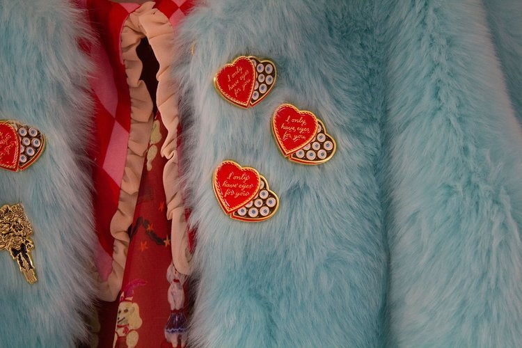 A few of the pins on a blue furry coat.