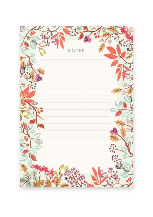 A lined notepad with a border of leaves and berries in shades if mint, purple, red and brown.