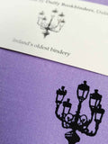 A close up of the lamp illustration also showing the texture of the light purple cloth cover.