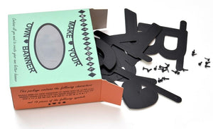 A light green box with orange sides and product details in black. Various flat, black letters are spilling out of the box.