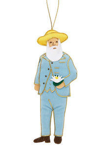 A felt man with a white beard wearing a yellow hat and blue suit detailed in gold thread, holding a water lily flower, hanging from a gold thread.