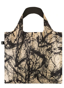 A square bag covered in black paint splatter and strokes against a cream background. The handle lining is black.