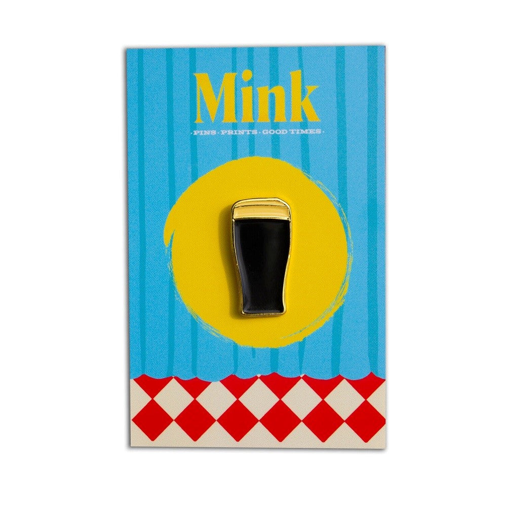 Soft enamel pin in the shape of a full pint of Guinness, with gold plating and rubber clutches, displayed on a blue and yellow card with red and white checkers at the bottom and with 'Mink' branding.