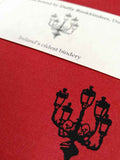 A close up of the lamp illustration also showing the texture of the red cloth cover.