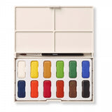 An open white box with a small paintbrush and twelve paint pans inside.