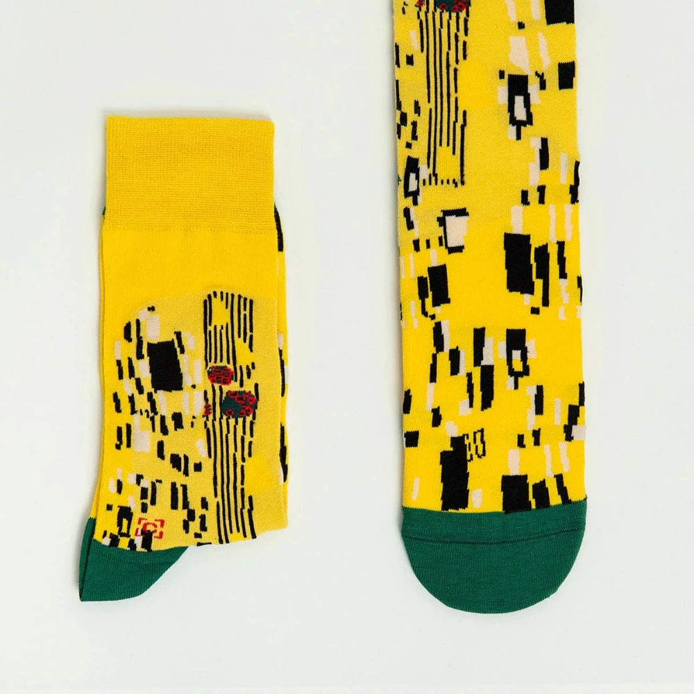 The yellow sock is covered in a pattern of black and white squarish shapes. The toe and heel are dark green.