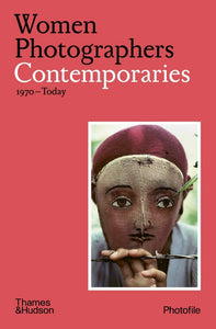 A red cover with a photo in the bottom right of a woman wearing a simple mask of a face. The title is in the top left in black and white letters.