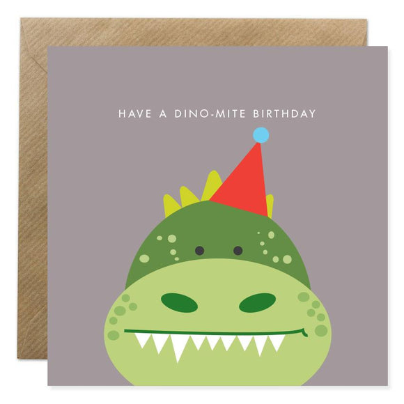A grey card with a cartoon dinosaur in a party hat. Have A Dino-mite Birthday is above in small white capitals.
