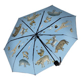 The underside of an open umbrella with illustrations of different animals against a sky blue background. The handle is black.