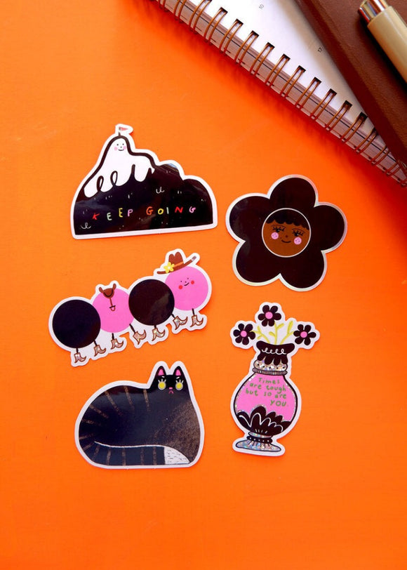 A set of 5 black, white and pink stickers of a cat, a vase, a mountain, a caterpillar and a flower with a face in the centre.